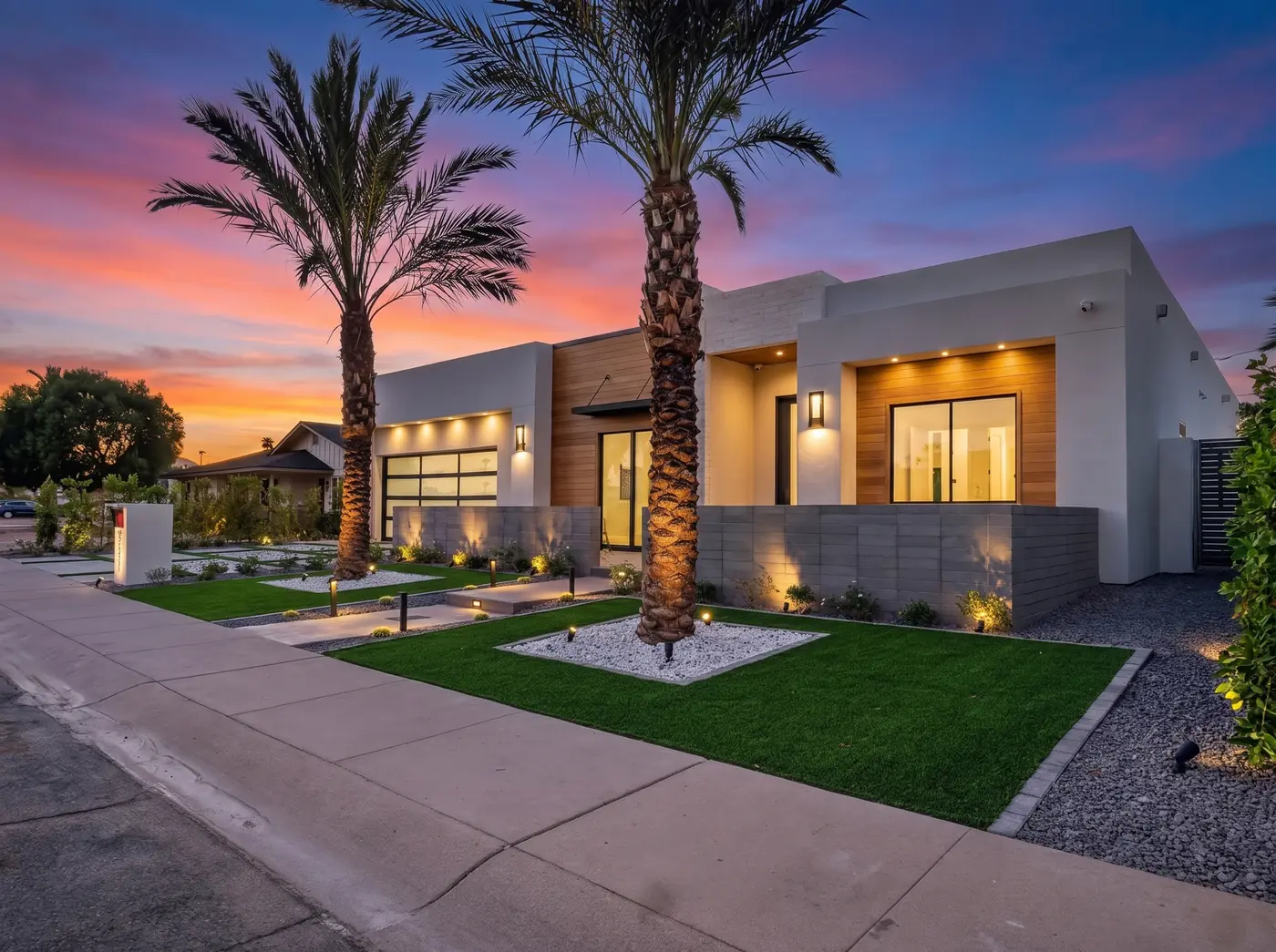 Modern home exterior at twilight with palm trees
